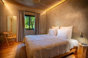 a bedroom with a bed in a room with a window at Casa Aromas in Santo Amaro