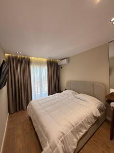 a bedroom with a large bed and a window at FIN Skyline Apartment in Krujë