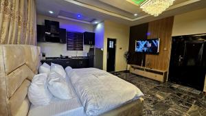 a bedroom with a bed with a television in it at Skye Palace Apartment - Ambassador Suite in Akure
