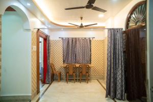 a dining room with a ceiling fan and a table and chairs at The Tulsi Enclave Riverside in Agartala