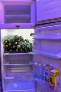 an open refrigerator filled with bottles of water at Skye Palace Apartment - Ambassador Suite in Akure
