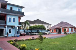 a group of houses with cars parked in a parking lot at Skye Palace Apartment - Ambassador Suite in Akure