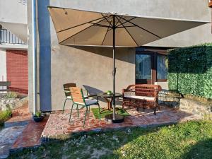 a patio with a table and chairs and an umbrella at Studio apartman EMA in Brodski Varoš