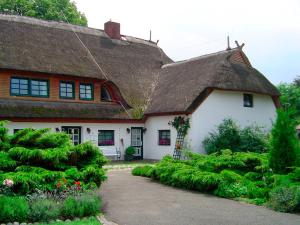 a white house with a thatched roof at Pension Forstfuhrmannshof in Markgrafenheide