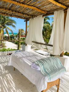 a bedroom with a bed under a wooden roof at Casa Omero Garden in El Cuyo