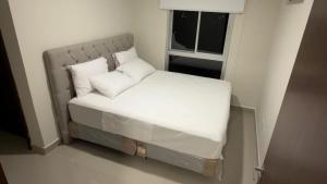 a small bed in a small room with a window at Premium Apartamento en Lambare in Asunción