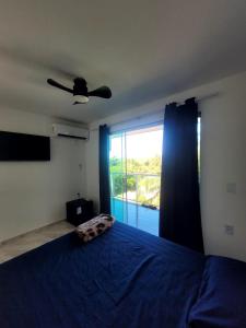 a bedroom with a blue bed and a large window at Pousada Terraço do Peró Cabo Frio Há 200 metros da Praia in Cabo Frio +53 photos