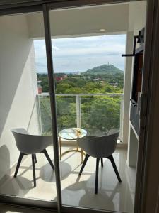 a balcony with a table and chairs in front of a window at Premium Apartamento en Lambare in Asunción