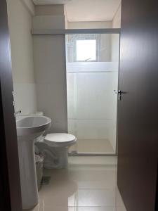 a bathroom with a toilet and a glass shower door at Premium Apartamento en Lambare in Asunción +13 photos