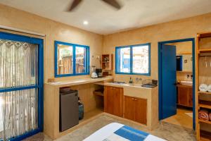 a kitchen with wooden cabinets and a sink and windows at Casa Omero Garden in El Cuyo