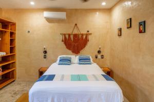 a bedroom with a bed with blue pillows on it at Casa Omero Garden in El Cuyo