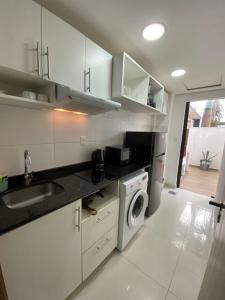 a kitchen with a sink and a washing machine at Edificio Juan XXIII - 2 Dormitorios - Zona Shopping Del Sol in Asunción