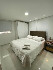 a bedroom with a large white bed with towels on it at Edificio Juan XXIII - 2 Dormitorios - Zona Shopping Del Sol in Asunción