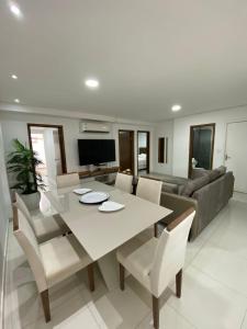 a dining room and living room with a white table and chairs at Edificio Juan XXIII - 2 Dormitorios - Zona Shopping Del Sol in Asunción