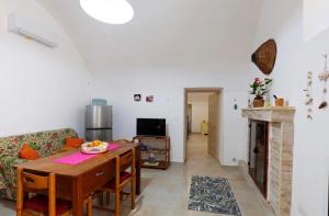 a living room with a table and a fireplace at Le Pozzelle Presicce, Bilocale Casa a Corte XVI sec in Presicce
