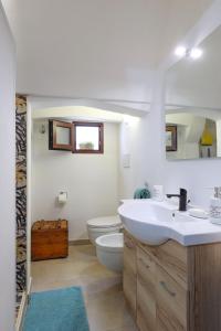 a white bathroom with a sink and a toilet at Le Pozzelle Presicce, Bilocale Casa a Corte XVI sec in Presicce +16 photos