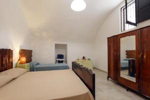 a bedroom with a bed and a mirror at Le Pozzelle Presicce, Bilocale Casa a Corte XVI sec in Presicce