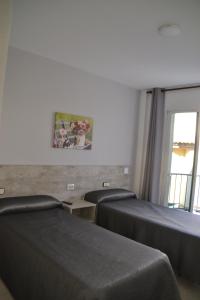 a hotel room with three beds and a window at Hotel Congra in Pilar de la Horadada