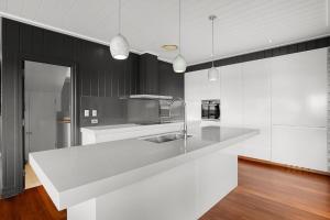 a kitchen with a white counter top and black cabinets at Dolphins at Sunset in Amity Point
