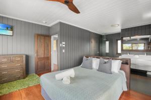 a bedroom with a bed and a bathroom with a sink at Dolphins at Sunset in Amity Point