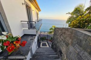 a staircase leading up to a house with a view of the ocean at Skyline Villas Room in Calheta