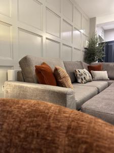 a living room with a gray couch with pillows at No 6 Lansdowne in Portrush