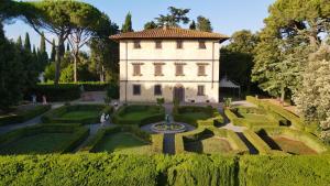 a building with a fountain in the middle of a garden at Fattoria La Loggia in San Casciano in Val di Pesa