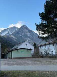a white building with a mountain in the background at Ferienwohnung Nora in Vordernberg