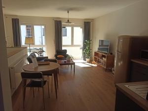 ein Wohnzimmer mit Tisch und Sofa sowie eine Küche in der Unterkunft Auszeitbude Mudau, FeWo auf 48 m2 in Mudau