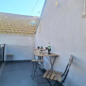 a table with two glasses of wine and two chairs at Ares do mar - Loft and terrace in Matosinhos +9 photos