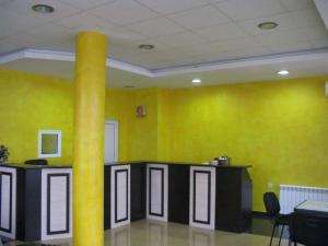 une chambre avec des murs jaunes et un pilier jaune dans l'établissement Hotel Nakra, à Radnevo