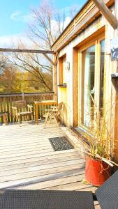 a wooden deck with a table and chairs on it at Boutique Loft "Mrs Green" im Thayatal, Tiny Haus in Drosendorf Stadt