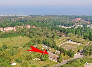 a red plane is flying over a house at Pension Forstfuhrmannshof in Markgrafenheide