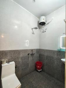 a bathroom with a red toilet and a sink at The Hills & Waves in Rishīkesh