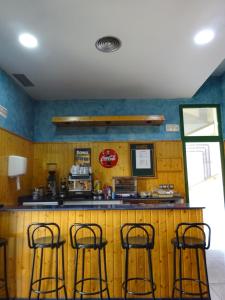 a kitchen with three bar stools at a counter at Hotel Congra in Pilar de la Horadada