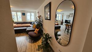 a living room with a mirror and a couch at Studio - Charmant, Gemütlich & Zentral in Landsberg am Lech