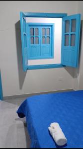 a bed with a blue door and a towel on it at Quindio Mio in Filandia
