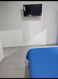 a bedroom with a bed and a tv on a wall at Quindio Mio in Filandia +13 photos