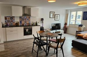 a kitchen and living room with a table and chairs at Studio - Charmant, Gemütlich & Zentral in Landsberg am Lech