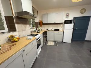a kitchen with white cabinets and a blue door at La Dryade in Braux +5 photos