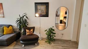 a living room with a chair and a mirror at Studio - Charmant, Gemütlich & Zentral in Landsberg am Lech