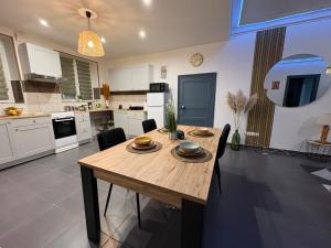 a large kitchen with a wooden table and chairs at La Dryade in Braux