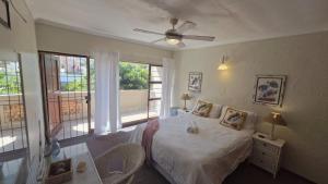 a bedroom with a bed and a ceiling fan at Beach Bliss Retreat in Margate