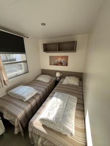 a bedroom with three beds in it with a window at VI05 Village 05 in Vias