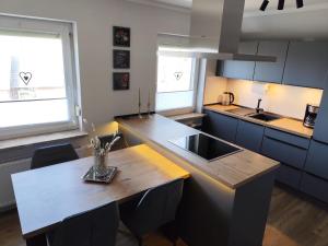 a kitchen with a wooden table and a counter top at Waldnest am Meer in Varel