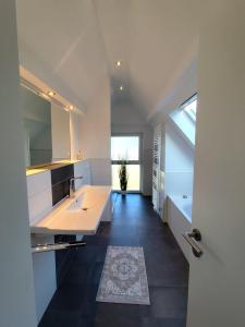 a white kitchen with a sink and a mirror at Waldnest am Meer in Varel +17 photos