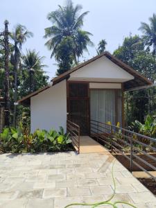 a small house with a whiteboard in front of it at Spice Garden Clove Villa in Batheri