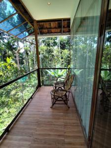 a screened porch with two benches on it at Spice Garden Clove Villa in Batheri