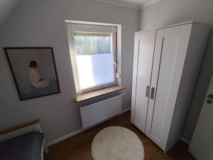a room with a window and a chair and a stool at Waldnest am Meer in Varel