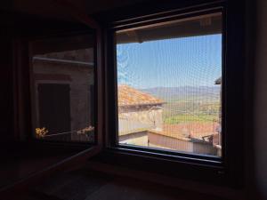 a window with a view of a mountain view at Campanile N1 in Montemerano